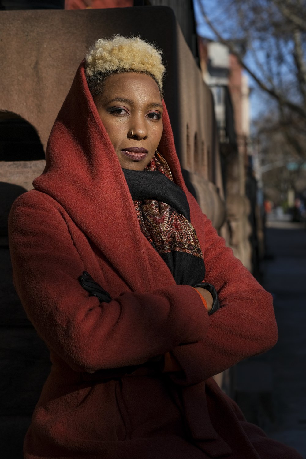 A woman stands in a warm patch of sunlight.