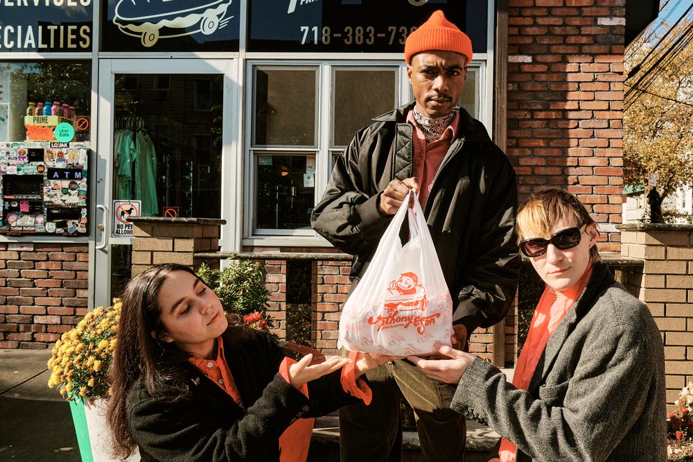 Eleonore Condo, Hunter Speese and Peter Smith hold a bag of sandwiches outside of Anthony & Son Panini Shoppe in Williamsburg.