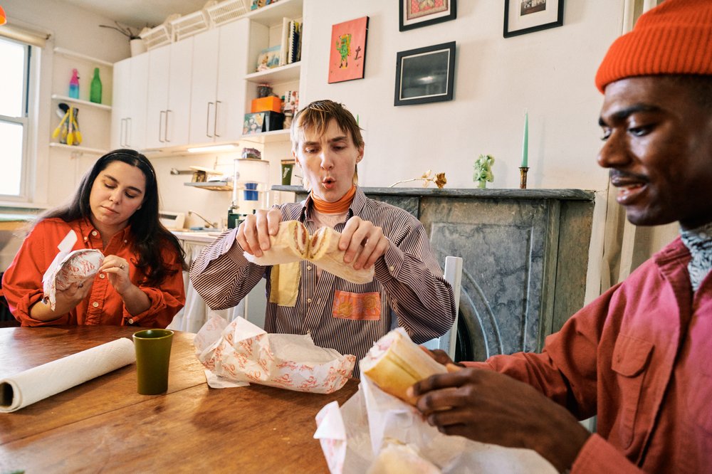 Eleonore Condo, Peter Smith and Hunter Speese sit around Smith’s kitchen table.