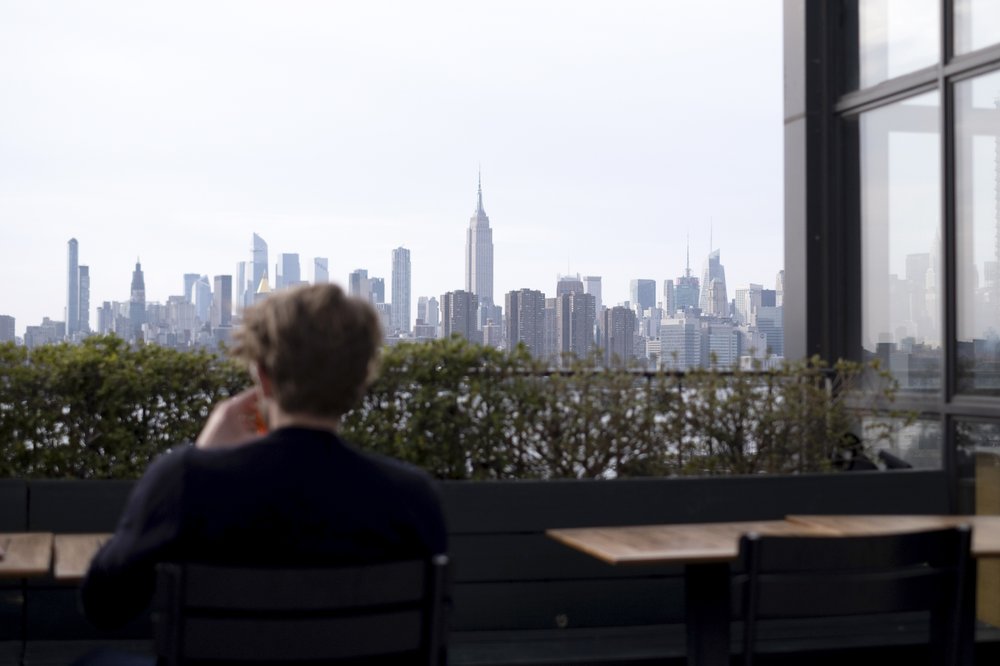 A man with a beverage in a rooftop bar