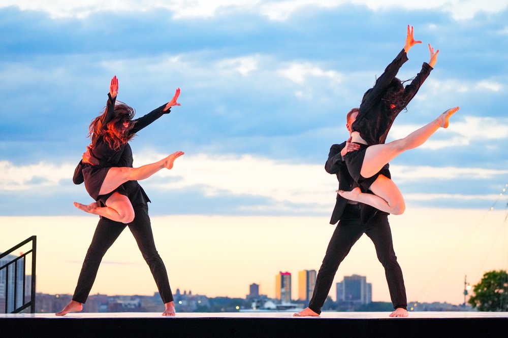 A dancer performs with a skyline in the background.