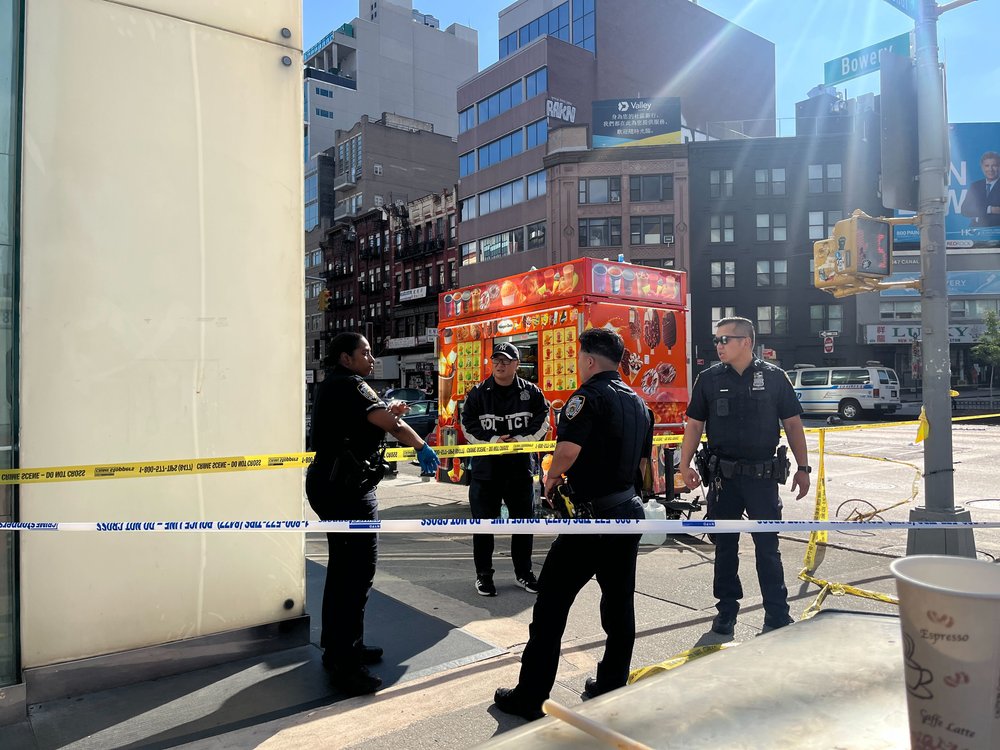Four police officers talk at the scene of a fatal collision near the Manhattan Bridge in Chinatown.