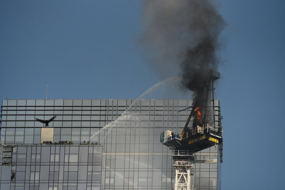 A photo of firefighters dousing flames on a high-rise crane after a partial collapse Wednesday.