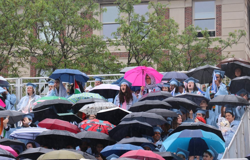 A photo of Columbia grads during a rainy commencement Wednesday