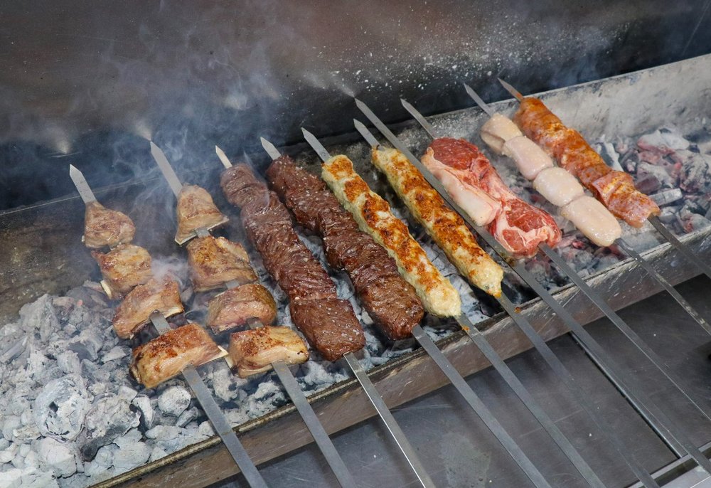 Skewers of meat over a grill.