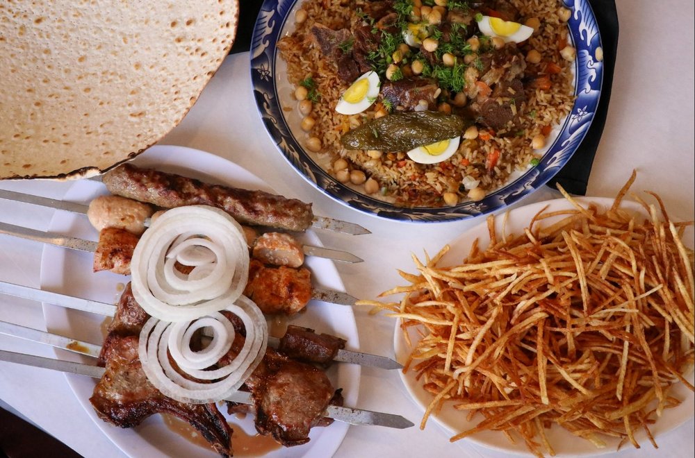 Three dishes on a table with a white tablecloth