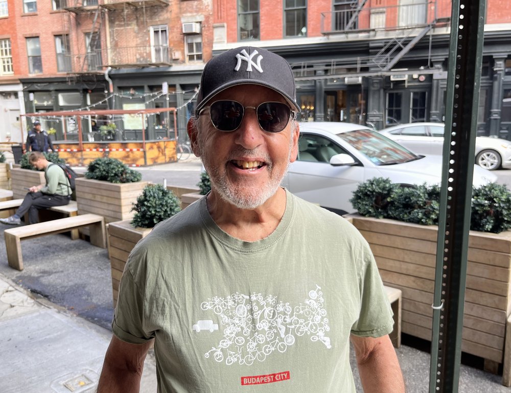 A man poses with a Yankees cap.