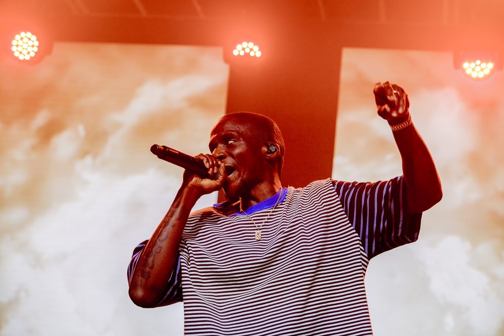 A man performs on a stage with a microhone