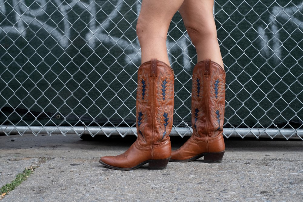 A close-up of tan leather cowboy boots.
