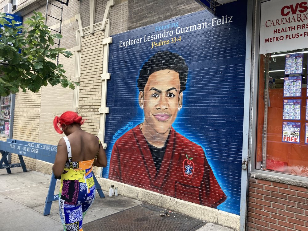 A woman passes by a mural of Lesandro Guzman-Feliz, the 15-year-old boy fatally stabbed in the Belmont section of the Bronx in June 2018.