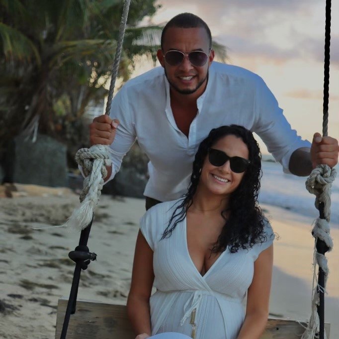 A man and woman stand on a beach.