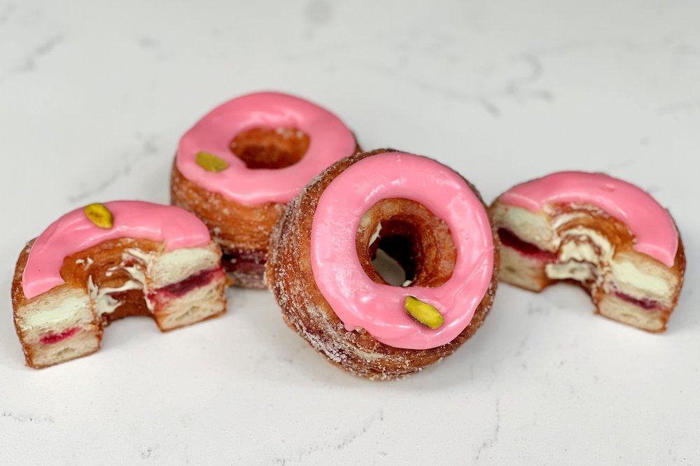 A picture of two pink cronuts, and two cronut-halves.