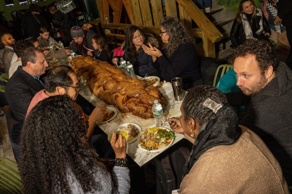 Photo of participants in the Shabbat dinner hosted by the Palestinian-owned restaurant Ayat in the Ditmas Park section of Brooklyn. The event was billed as an opportunity to break "bread" and "barriers" against the backdrop of war in Gaza and spreading violence in the Middle East.