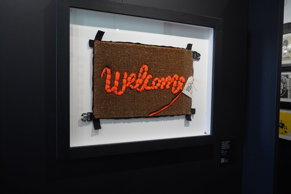 A photo of Banksy's "Welcome (Gross Domestic Product)"