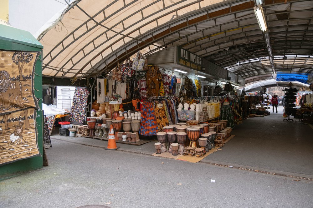 Drums, clothing and baskets are on display in a covered market