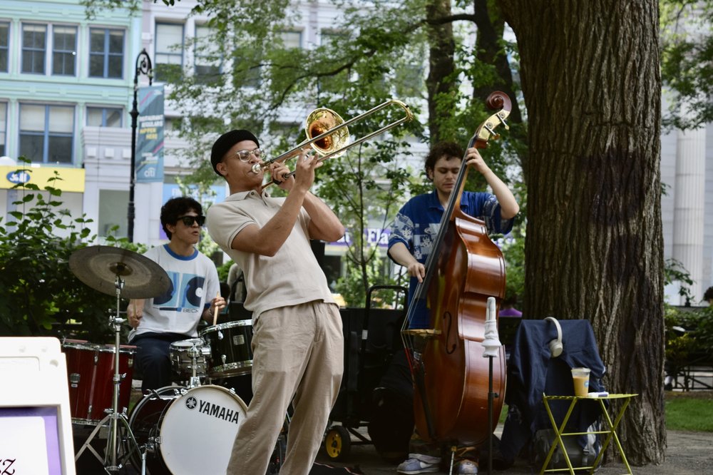 A man plays an instrument in the park.