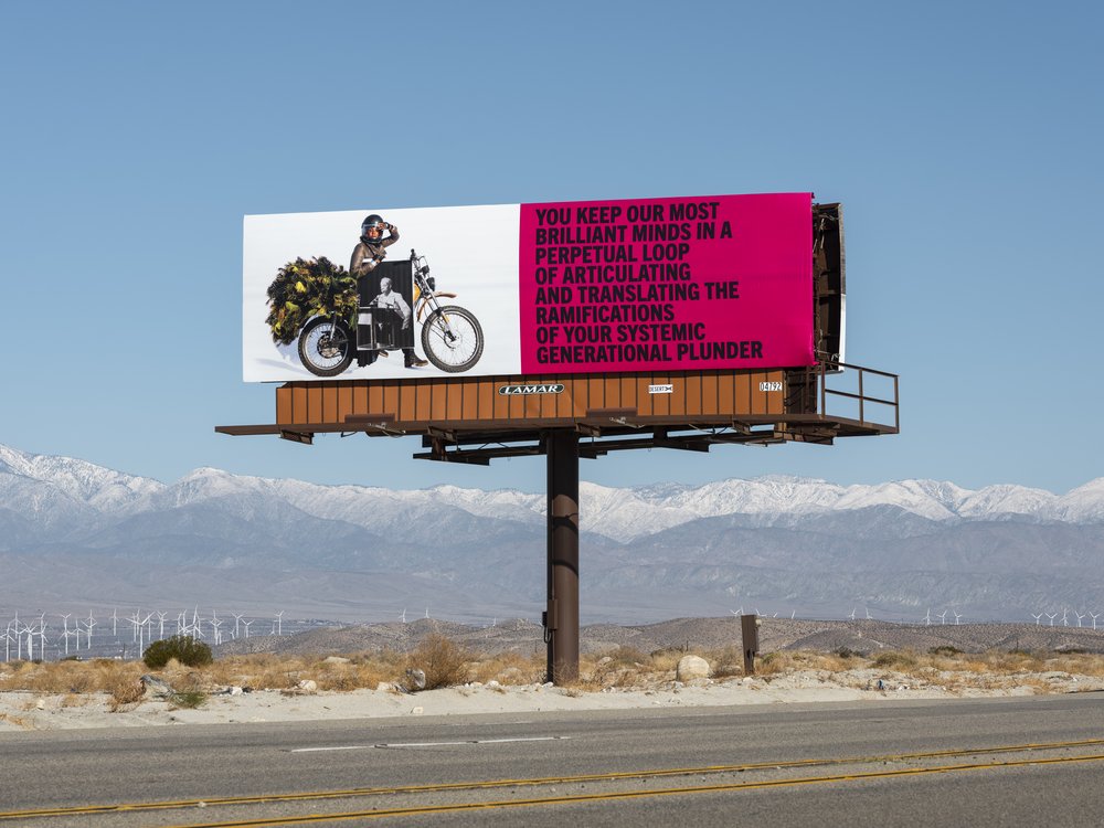 A billboard standing over a street.