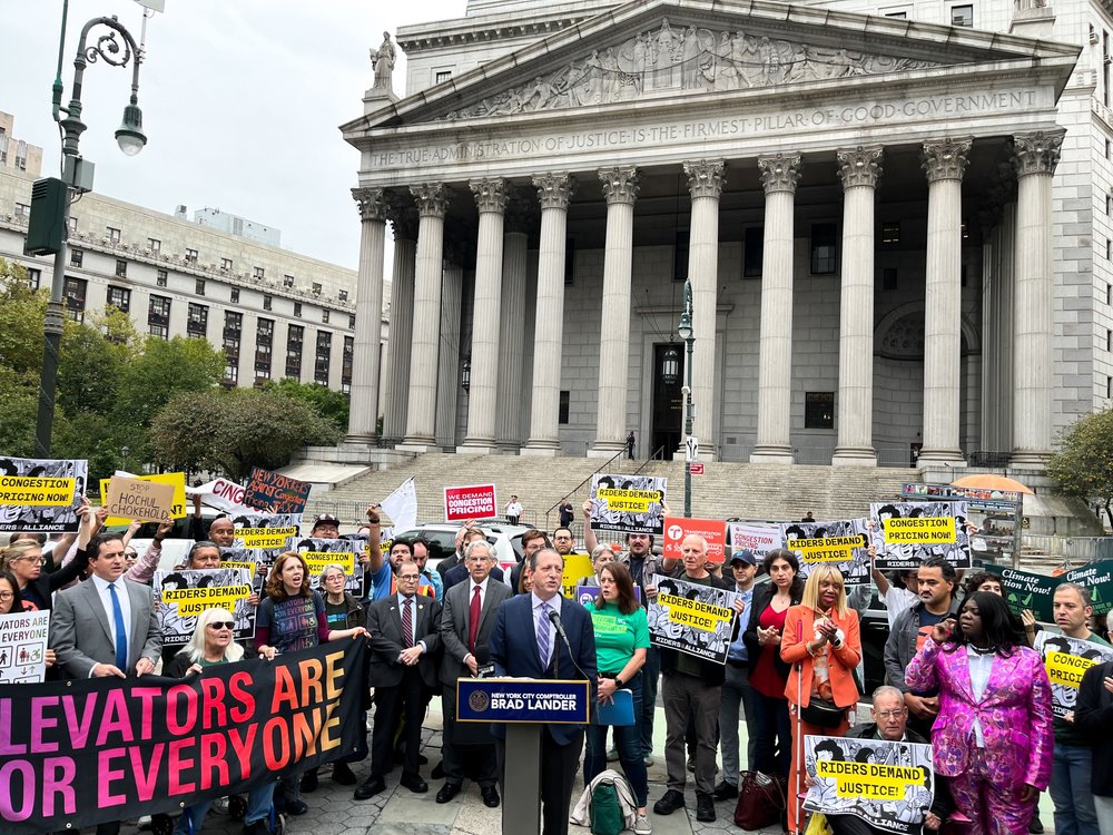 Comptroller Brad Lander speaks in front of a courthouse, surrounded by supporters.