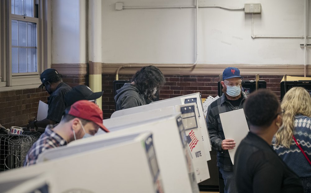 A scene of people voting at a voting site.