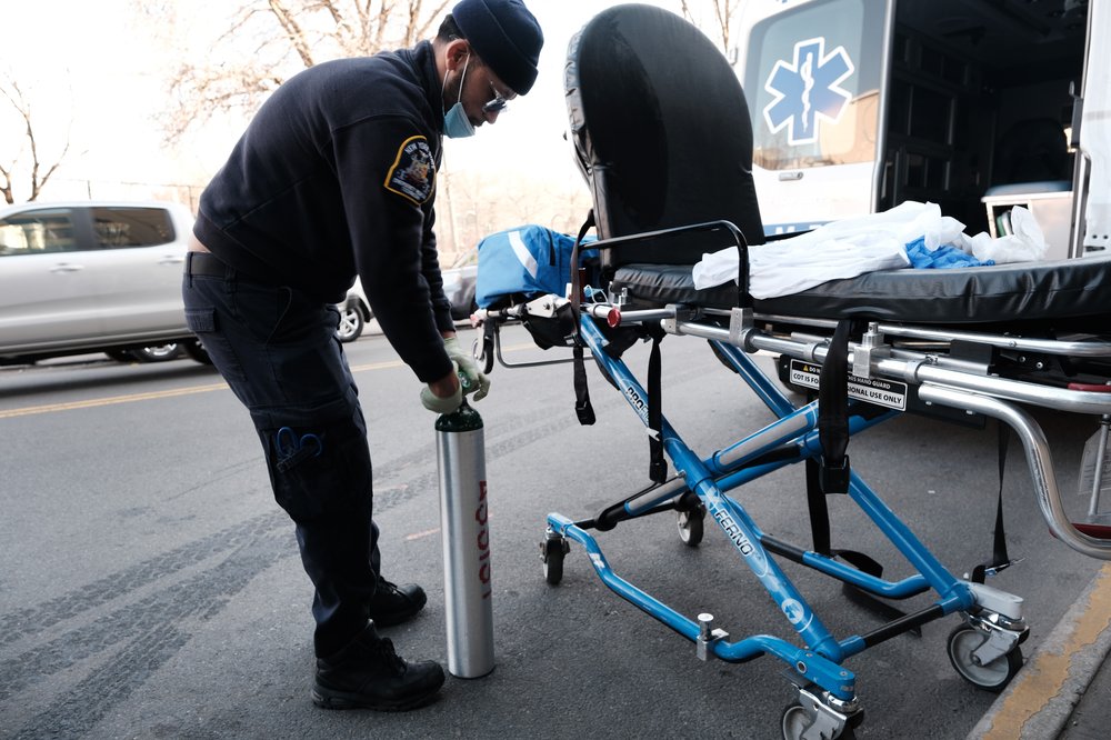An EMS worker cleans a gurney.