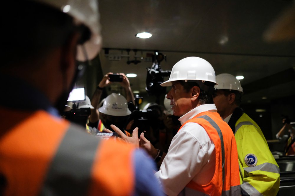 Governor Cuomo, in hardhat and orange vest, talks to press