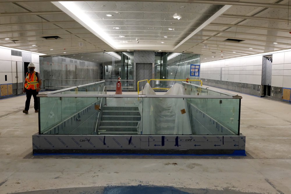 An escalator going down to another level is surroudned by a glass railing