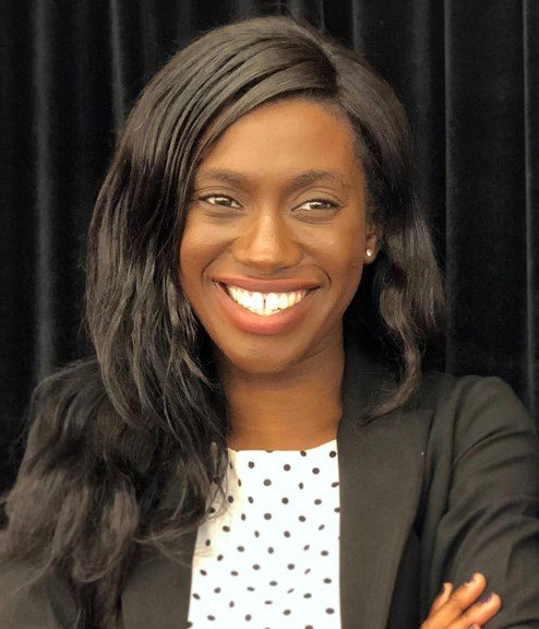 A headshot of a woman with crossed arms