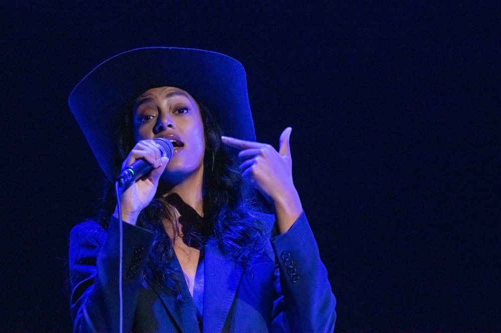 Close up photo of a woman singing onstage.