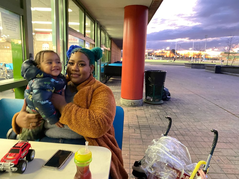 Allandra Washington, joined by her 1-year-old son, wait outside at Denny Farrell Riverbank State Park, while her 6-year-old daughter was learning how to ice skate.