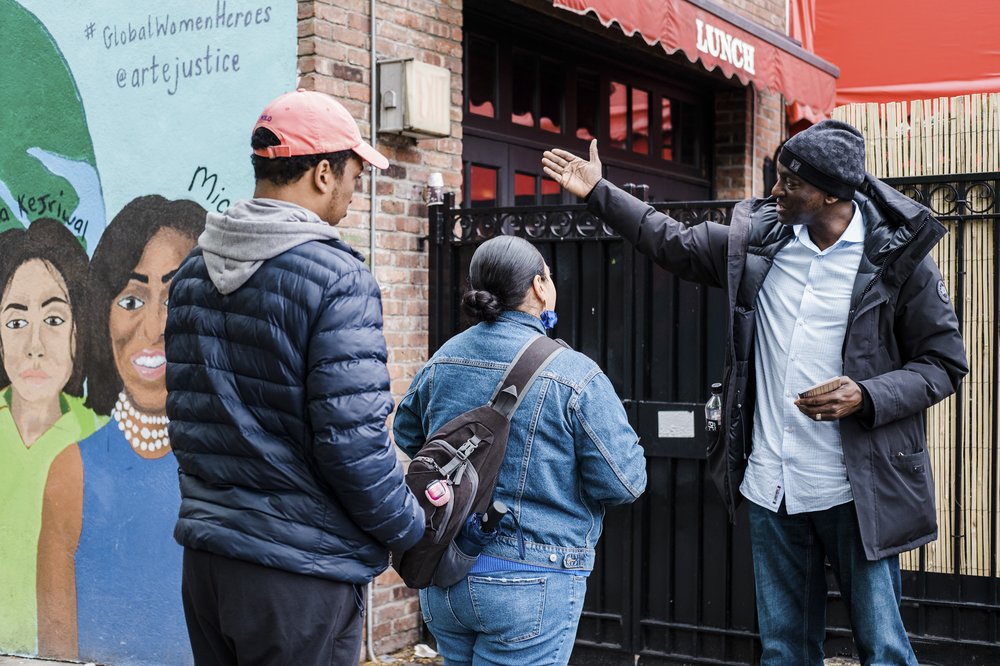 A person speaks to people passing on the street.