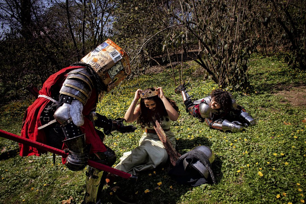 Two gladiators battle over a princess who is seated in the grass.