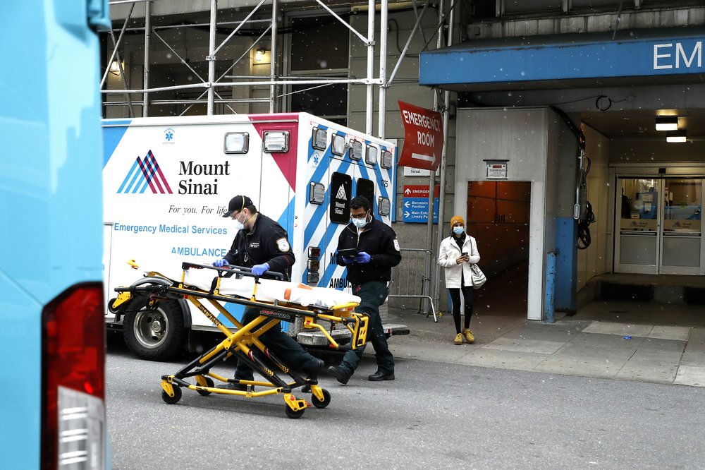 Emergency Medical Technicians move a gurney out of the emergency entrance into an ambulance at Mt. Sinai-Beth Israel Hospital in 2020.