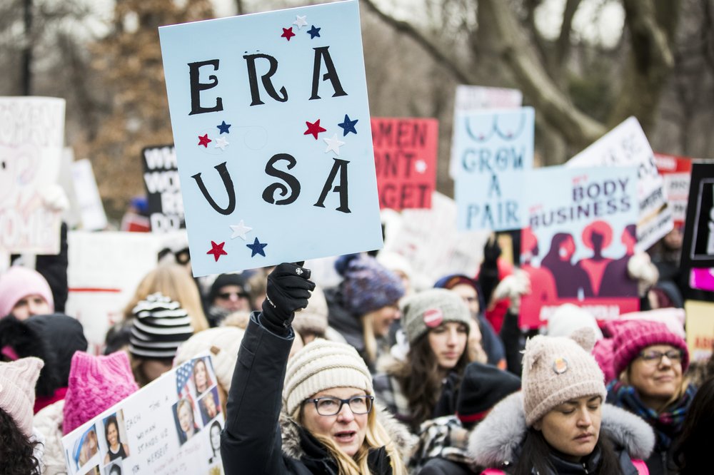A demonstrator holds an "ERA USA" sign.