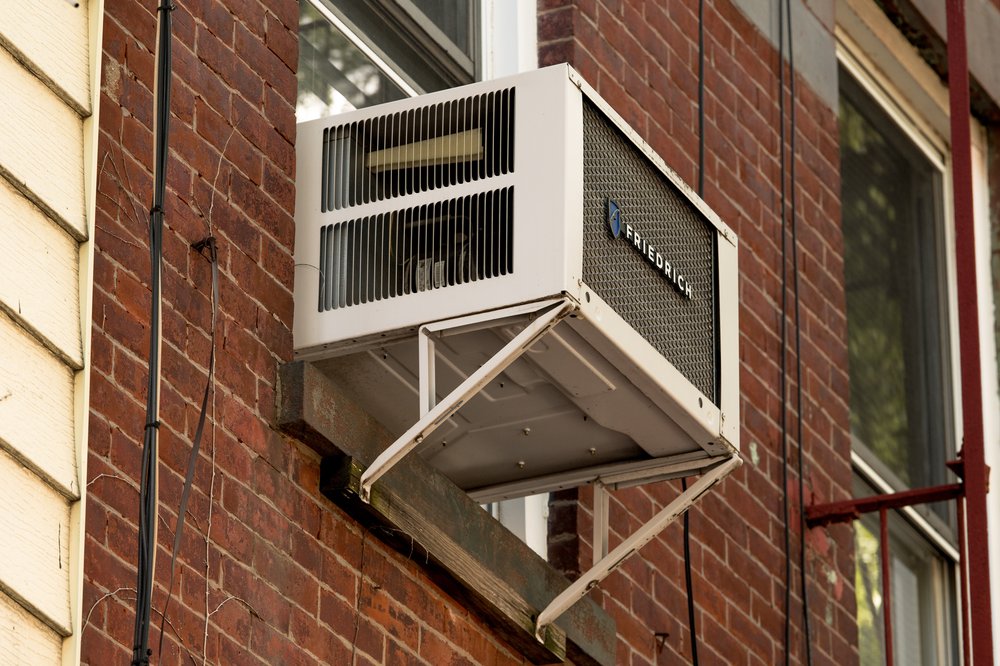 An air conditioner is seen in a residential window.