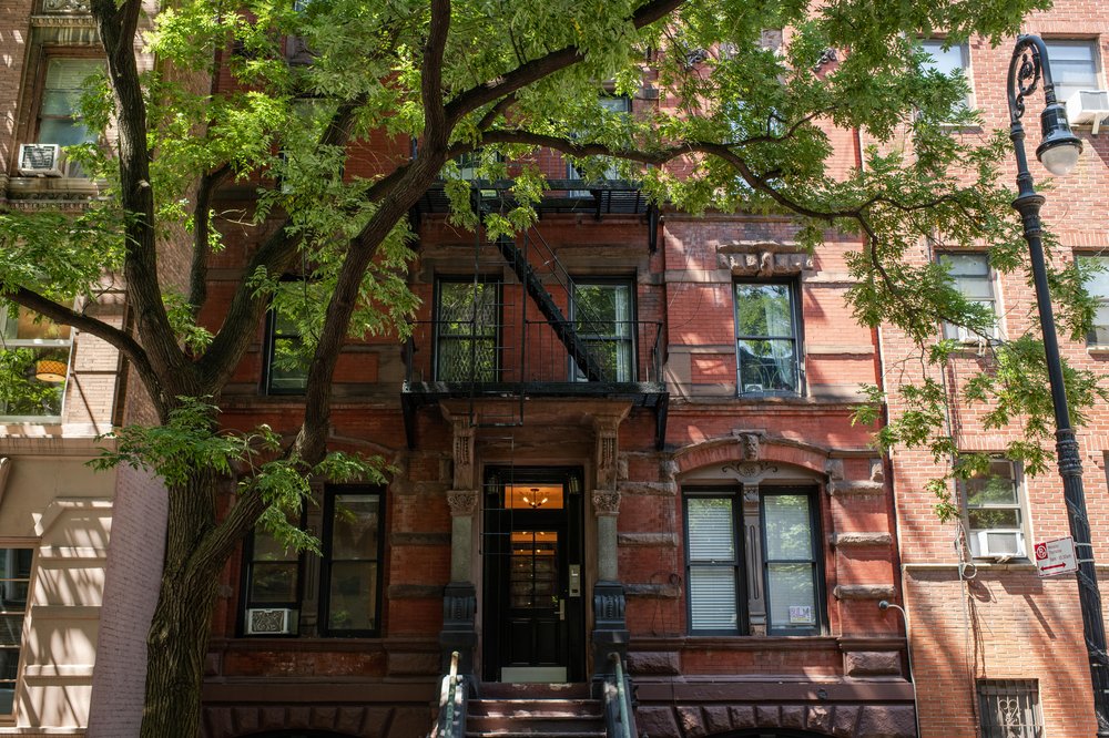 A tree shades a brick rent stabilized apartment building in the West Village