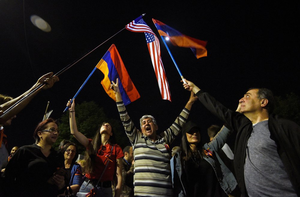People wave Armenian and U.S. flags in front of the American embassy in Yerevan after President Joe Biden recognized the 1915 killings of Armenians by Ottoman forces as genocide, on April 24, 2021. He became the first U.S. president to use the word genocide in a statement on the anniversary. of the carnage, which claimed as many as 1.5 million lives.