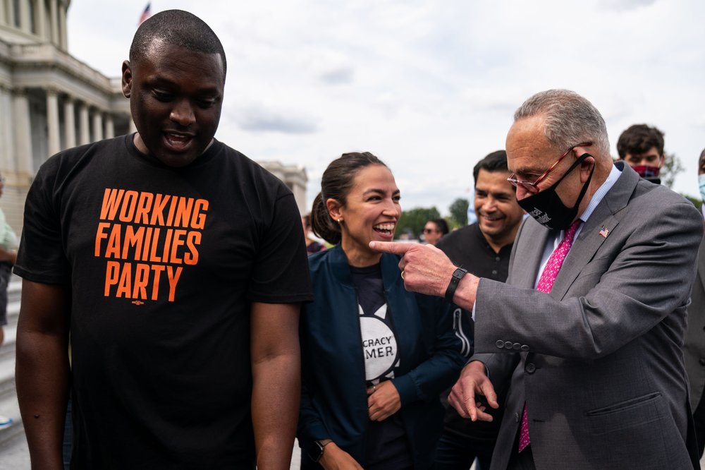 Former Rep. Mondaire Jones, in a t-shirt that says WORKING FAMILIES PARTY, with Rep. Alexandria Ocasio-Cortez and Sen. Chuck Schumer