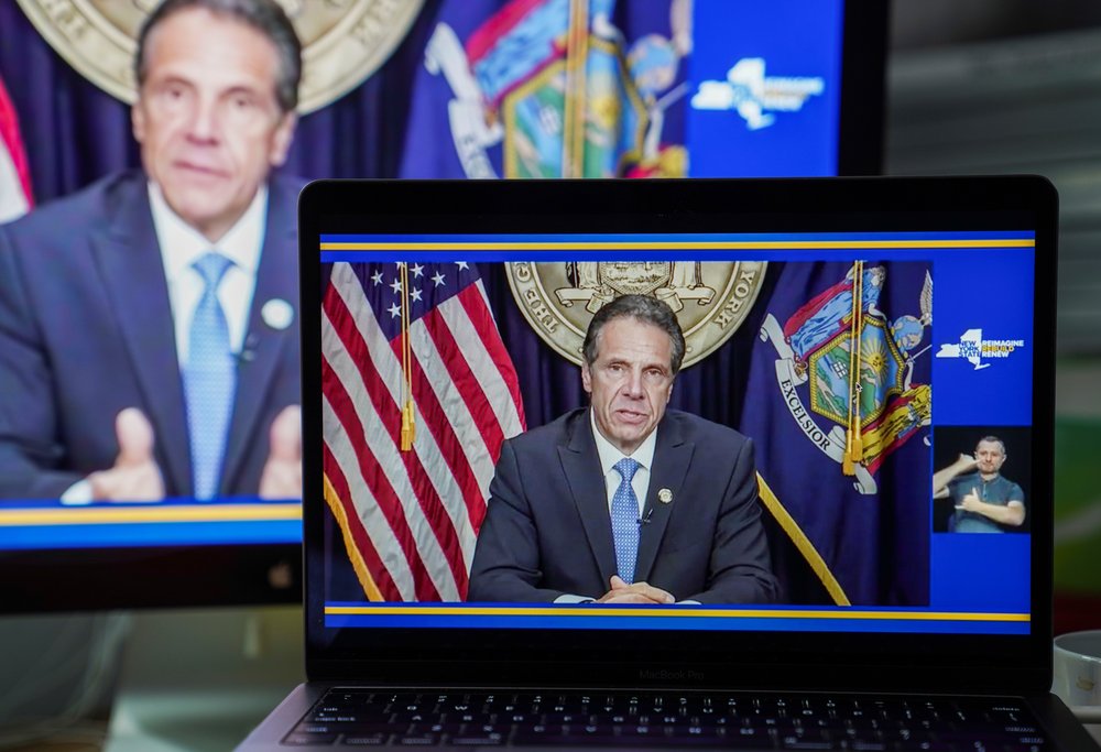 A laptop shows former Gov. Andrew Cuomo's resignation address as he sits in front of the American flag and the New York state flag