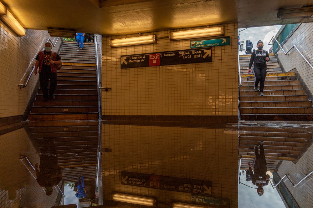 Commuters walk into a flooded 3rd Avenue-149th Street subway station and disrupted service due to extremely heavy rainfall from the remnants of Hurricane Ida on Sept. 2, 2021.