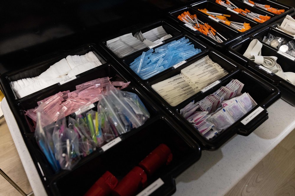 Bandaids, gauze, syringes and other medical equipment is neatly sorted in a case at a supervised drug injection facility.