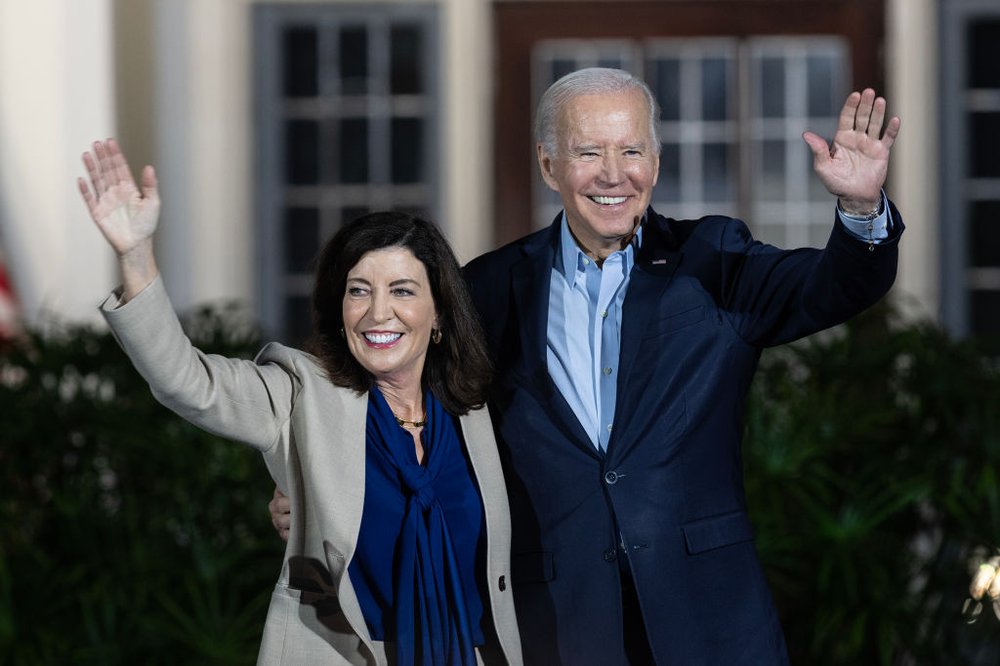 Gov. Kathy Hochul and President Joe Biden, standing alongside each other, wave at supporters