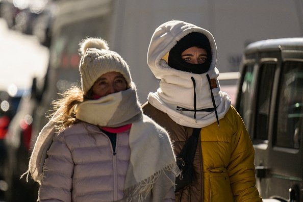 Two people wearing snow hats and face coverings.