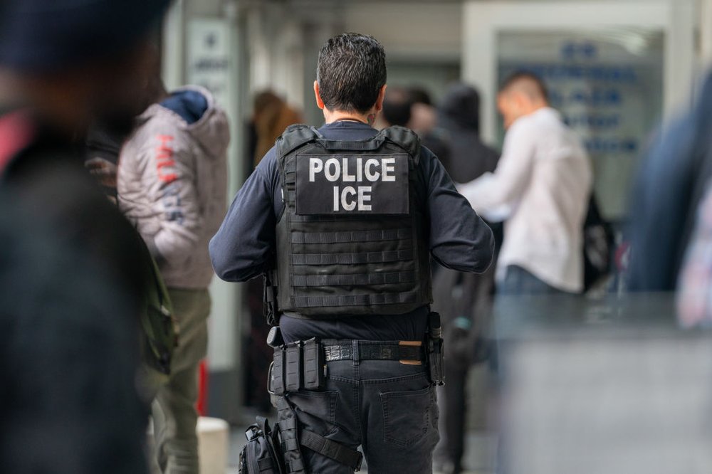An ICE agent monitors hundreds of asylum seekers being processed upon entering the Jacob K. Javits Federal Building on June 6, 2023, in New York City.