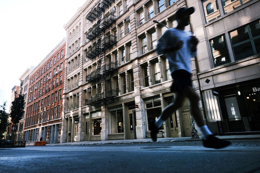A runner sprints past a series of buildings in Soho.