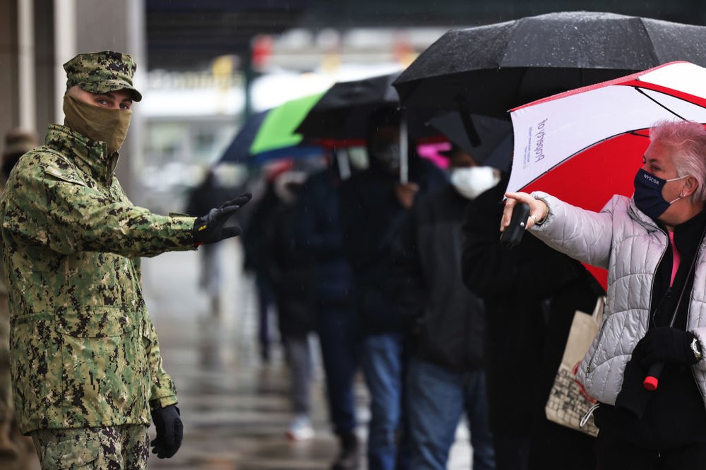 On Feb. 5, 2021, a National Guard soldier helps to enforce social distancing as people wait in line to enter the COVID-19 vaccination site at Yankee Stadium.