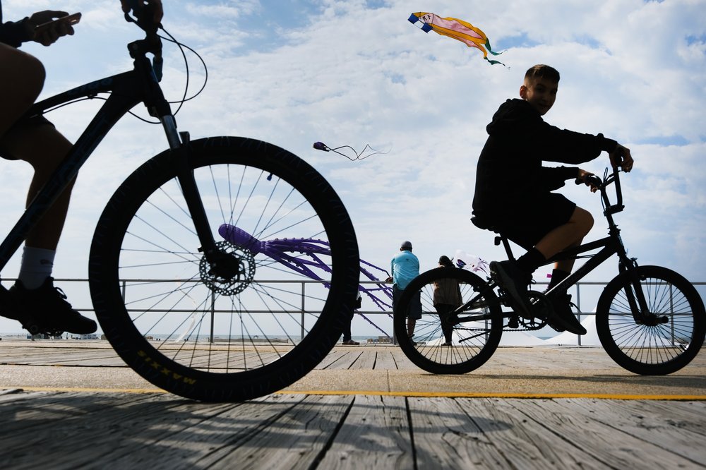 People walk and ride along the boardwalk the day before Memorial Day 2021 in Wildwood, New Jersey.