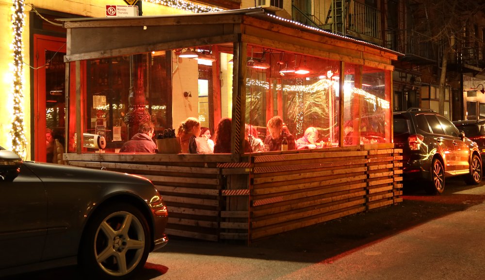 People eat dinner in an outdoor sidewalk shed at a restaurant on Bedford Street in Greenwich Village on Dec. 17, 2021 in New York City.