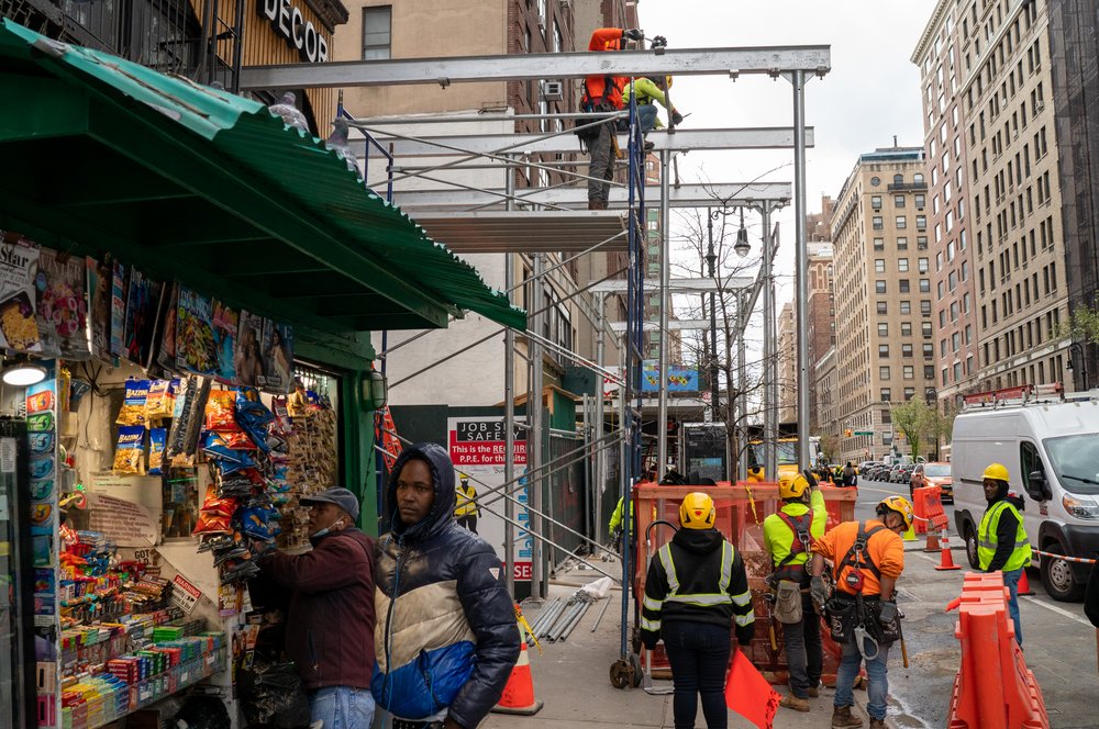 Workers put up a sidewalk shed in Manhattan on April 19, 2022.