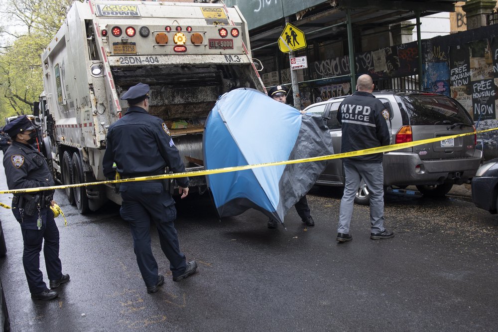 Police enforce a sweep of a homeless encampment, throwing tents and other possessions of the homeless in a trash truck, May 4, 2022 in the East Village neighborhood of New York City, New York. Mayor Adams has ordered the police and the sanitation department to remove structures on the streets where homeless people are living.