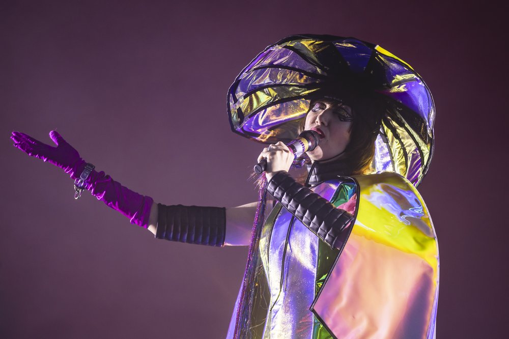 A singer onstage in a flamboyant outfit.